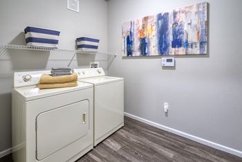 a washer and dryer in a laundry room with a painting on the wall